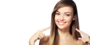 woman smiling and pointing at teeth