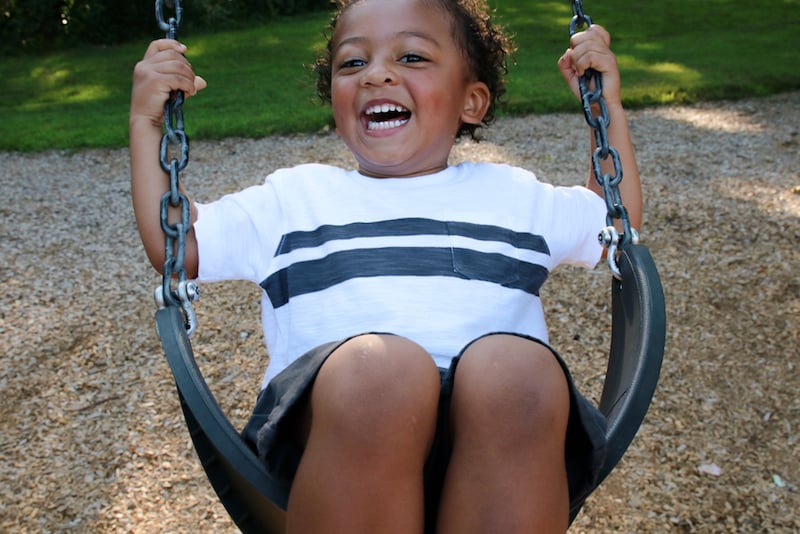 A kid on a swing in a park