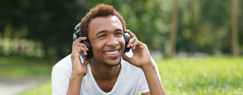 A man on headphones in a park