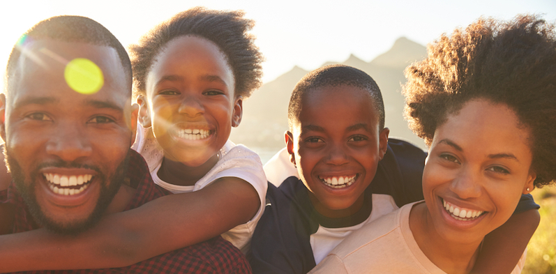 A smiling couple with 2 kids