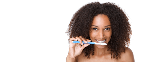 A woman with curly hair holding a toothbrush