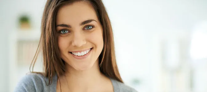 A woman smiling showing her white teeth